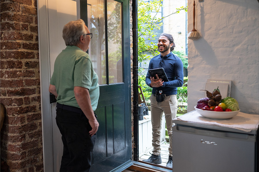 Elderly man opening the door to an engineer